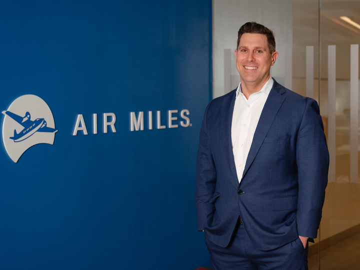 a man in a suit standing in front of a sign