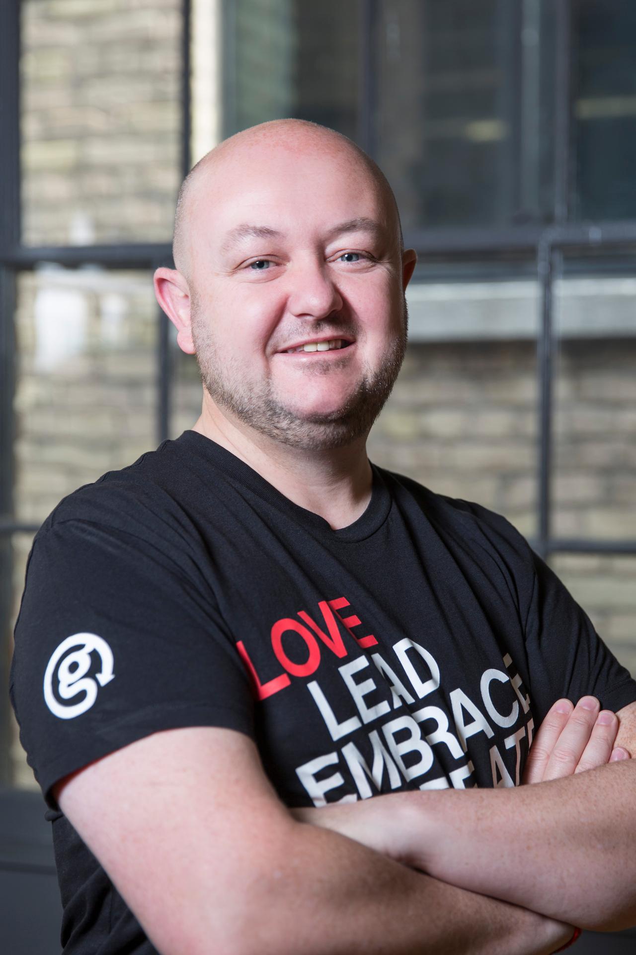 a man smiling with arms crossed